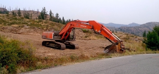 An excavator clearing land