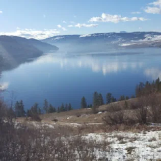 Kalamalka Lake seen from a hill partially covered with snow