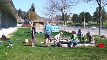 Students and instructors gathered around one of the planting beds